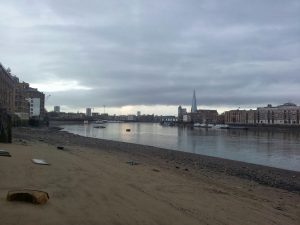 The River Thames at low tide with London buildings and the Shard in the distance