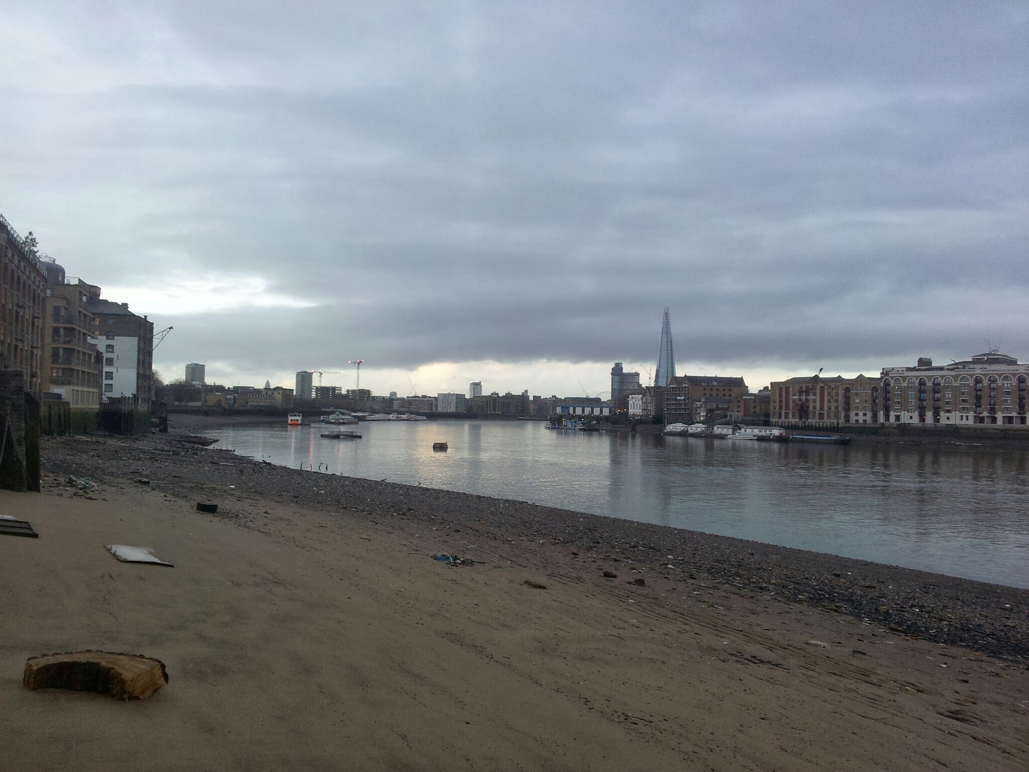 The River Thames at low tide with London buildings and the Shard in the distance